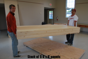 2-people-carry-stack-of-5x8-wall-panels
