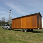 Classic wood tiny house storage unit towed behind a truck