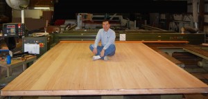 sitting on large 12 ft x 10 ft mahogany pivot door in factory